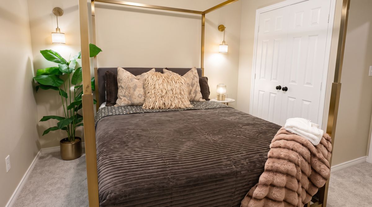 Queen bedroom with a gold canopy bed
