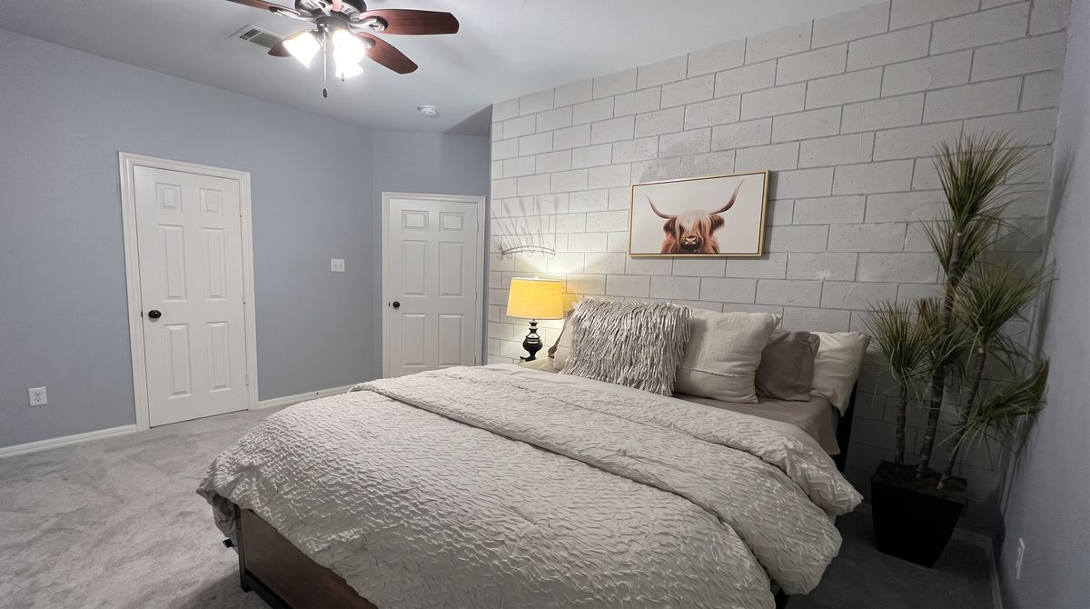 Queen bedroom with a white brick accent wall