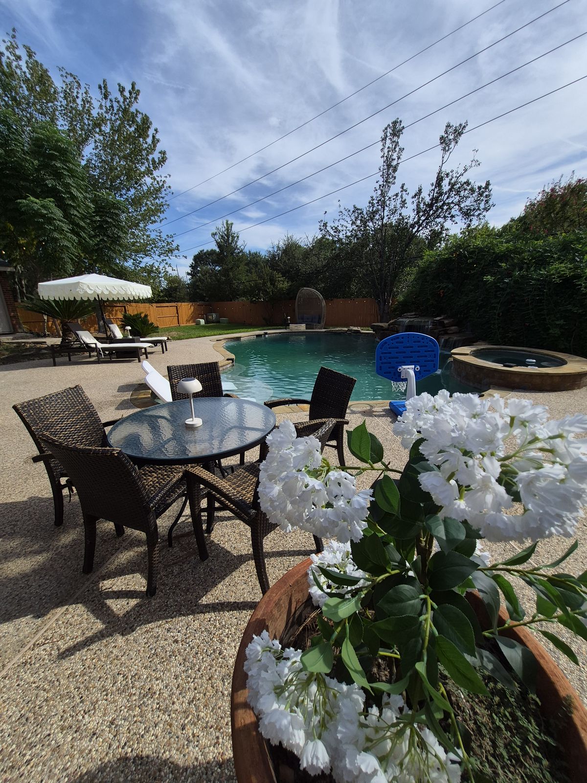 Patio table and chairs with the pool behind